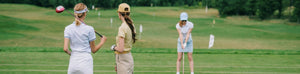 Three women playing golf on the course