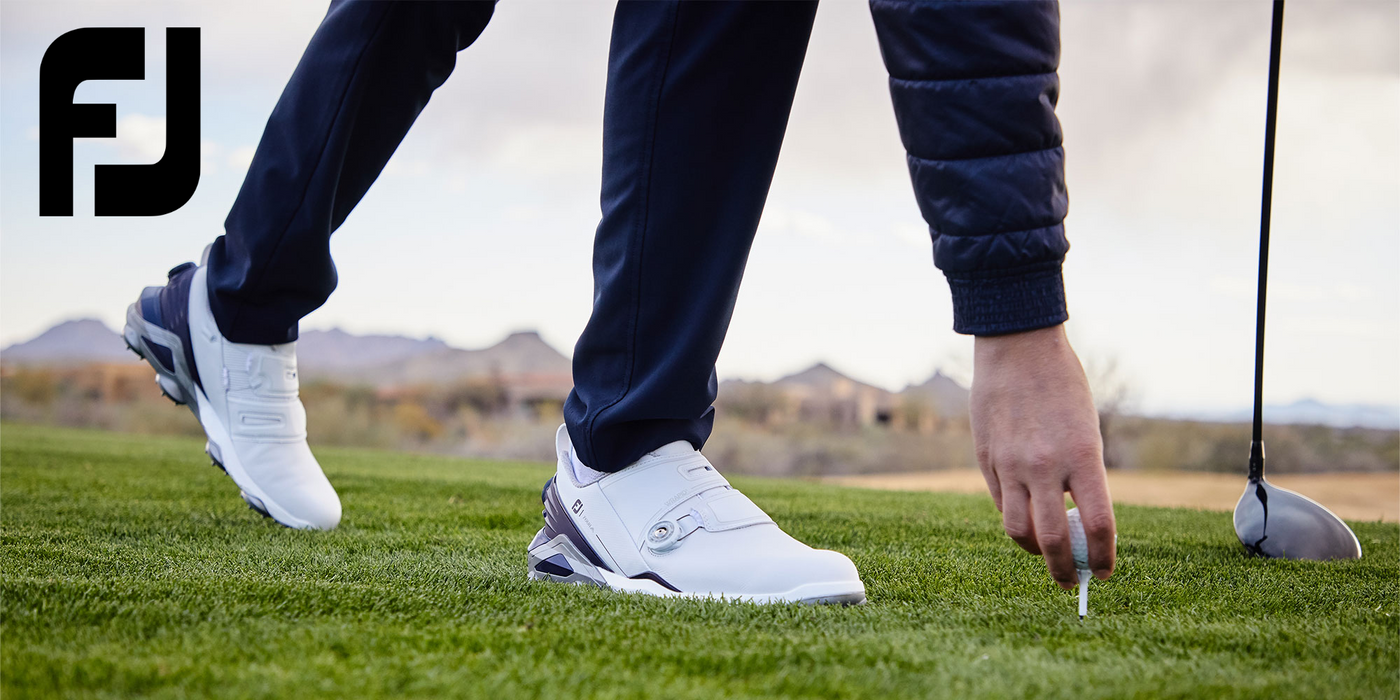 Golfer wearing FootJoy shoes teeing up golf ball